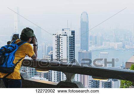 A tourist taking a picture, view from Victoria Peak of the island of Hong Kong; Hong Kong, China View Large Photo Image Stock Image - A tourist taking a picture, view from Victoria Peak of the island of Hong Kong; Hong Kong, China. Fotosearch