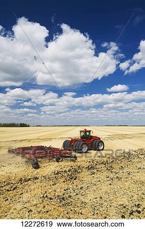 A tractor pulling a disc harrow works soil containing barley stubble, near Lorette; Manitoba, Canada View Large Photo Image Stock Photo - A tractor pulling a disc harrow works soil containing barley stubble, near Lorette; Manitoba, Canada. Fotosearch