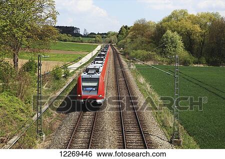 A train on the tracks in the countryside; Gilching, Bayern, Germany View Large Photo Image Stock Photograph - A train on the tracks in the countryside; Gilching, Bayern, Germany. Fotosearch