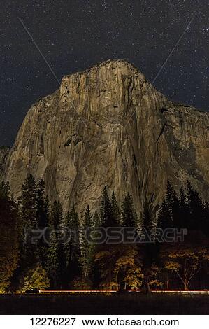 A vehicle drives along Northside Drive in front of El Capitan at night in Yosemite Valley, Yosemite National Park; California, United States of America View Large Photo Image Stock Photo - A vehicle drives along Northside Drive in front of El Capitan at night in Yosemite Valley, Yosemite National Park; California, United States of America. Fotosearch