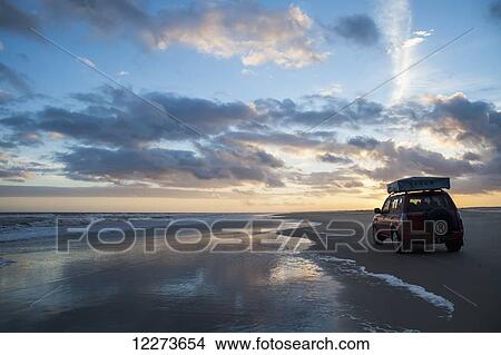 Picture - A vehicle sits on Casino Beach at sunset, the longest beach in the world; Rio Grande do Sul, Brazil. Fotosearch