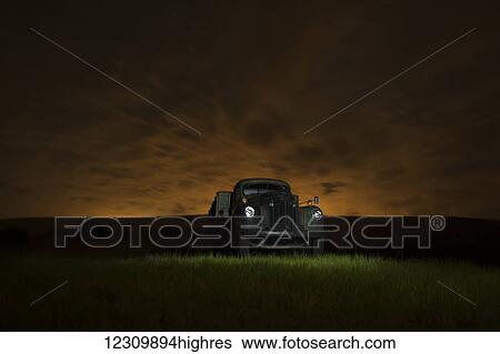 Stock Photograph - A vintage truck in a grass field at sunset; Palouse, Washington, United States of America. Fotosearch