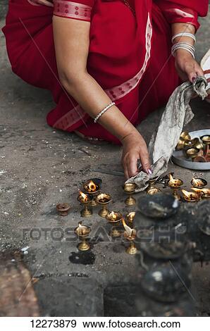A woman cleaning the candles in a Buddhist temple from Patan Durbar Square; Kathmandu, Nepal View Large Photo Image Stock Photo - A woman cleaning the candles in a Buddhist temple from Patan Durbar Square; Kathmandu, Nepal. Fotosearch