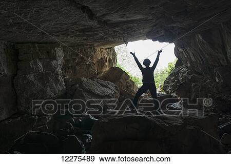 A woman stands silhouetted against the bright sky outside of a very large cave deep within Toro Toro National Park; Bolivia View Large Photo Image Stock Photo - A woman stands silhouetted against the bright sky outside of a very large cave deep within Toro Toro National Park; Bolivia. Fotosearch