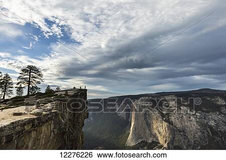 Stock Photograph - A Yosemite National Park visitor stands at Taft Point, which overlooks Yosemite Valley and El Capitan; California, United States of America. Fotosearch