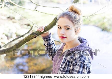 Stock Photograph - A young teenage girl holds a tree branch and New Westminster, British Columbia, Canada. Fotosearch