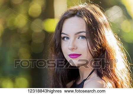 Stock Photograph - A young teenage girl looks at the camera over her shoulder; Vancouver, British Columbia, Canada. Fotosearch