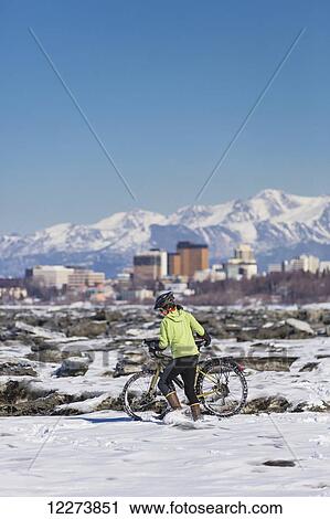 A Young Woman pushes her studded tire bicycle amongst the ice chunks in the Cook Inlet next to the Tony Knowles Coastal Trail, Anchorage, Southcentral Alaska, USA. View Large Photo Image Stock Image - A Young Woman pushes her studded tire bicycle amongst the ice chunks in the Cook Inlet next to the Tony Knowles Coastal Trail, Anchorage, Southcentral Alaska, USA.. Fotosearch