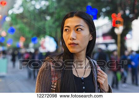 Stock Photo - A young woman shopping along the street, Kowloon; Hong Kong, China. Fotosearch