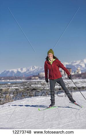 Stock Photo - A young woman skate skiing down the Tony Knowles Coastal Trail, Anchorage, Southcentral Alaska, USA.. Fotosearch