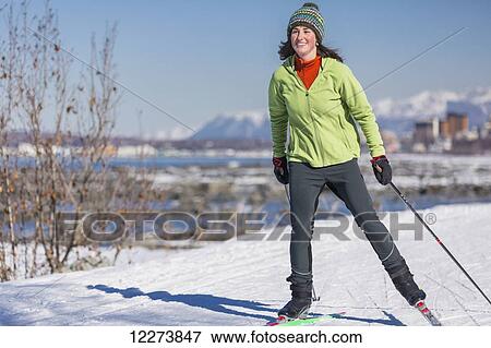 Stock Photo - A young woman skate skiing down the Tony Knowles Coastal Trail, Anchorage, Southcentral Alaska, USA.. Fotosearch