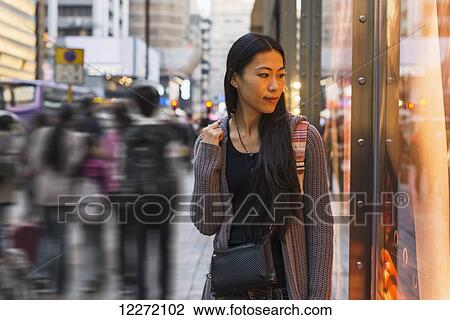 A young woman walking along the street and shops, Kowloon; Hong Kong, China View Large Photo Image Stock Image - A young woman walking along the street and shops, Kowloon; Hong Kong, China. Fotosearch