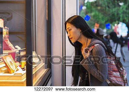 A young woman window shopping at the retail shops along the street, Kowloon; Hong Kong, China View Large Photo Image Stock Photo - A young woman window shopping at the retail shops along the street, Kowloon; Hong Kong, China. Fotosearch