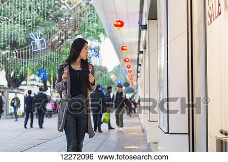 A young woman window shopping at the retail shops along the street, Kowloon; Hong Kong, China View Large Photo Image Stock Photograph - A young woman window shopping at the retail shops along the street, Kowloon; Hong Kong, China. Fotosearch