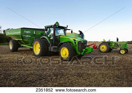 Stock Image - Agriculture - A farmer inspects a load of freshly harvested grain corn in a grain wagon during Autumn harvesting operations / Southern Iowa, USA.. Fotosearch