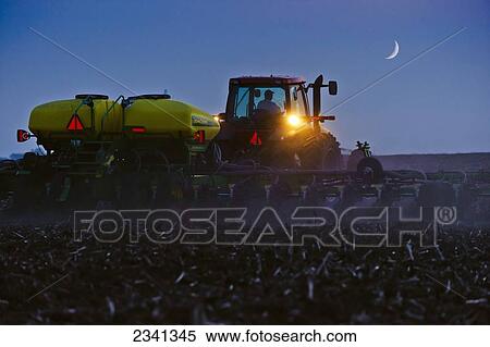 Agriculture - A farmer plants a soybean crop at night with a crescent moon above the field. Corn stubble is left over from the previous year's corn harvest / Central Iowa, USA. View Large Photo Image Stock Photography - Agriculture - A farmer plants a soybean crop at night with a crescent moon above the field. Corn stubble is left over from the previous year's corn harvest / Central Iowa, USA.. Fotosearch