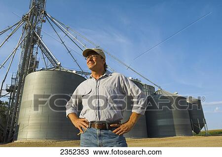 Agriculture - A farmer stands in his farm View Large Photo Image Stock Image - Agriculture - A farmer stands in his farm. Fotosearch