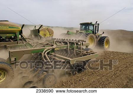 Agriculture - A John Deere tractor and air seeder planting garbanzo beans (chick peas) in the rolling hills of the Palouse Region / near Pullman, Washington, USA. View Large Photo Image Stock Image - Agriculture - A John Deere tractor and air seeder planting garbanzo beans (chick peas) in the rolling hills of the Palouse Region / near Pullman, Washington, USA.. Fotosearch