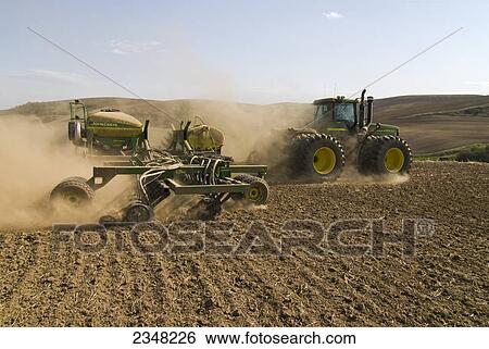 Agriculture - A John Deere tractor and air seeder planting garbanzo beans (chick peas) in the rolling hills of the Palouse Region / near Pullman, Washington, USA. View Large Photo Image Stock Photograph - Agriculture - A John Deere tractor and air seeder planting garbanzo beans (chick peas) in the rolling hills of the Palouse Region / near Pullman, Washington, USA.. Fotosearch