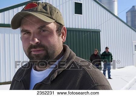 Agriculture - A poultry producer poses in the snow with his partner parents and poultry barns and silos in the background / near Strasburg, Pennsylvania, USA. View Large Photo Image Stock Image - Agriculture - A poultry producer poses in the snow with his partner parents and poultry barns and silos in the background / near Strasburg, Pennsylvania, USA.. Fotosearch