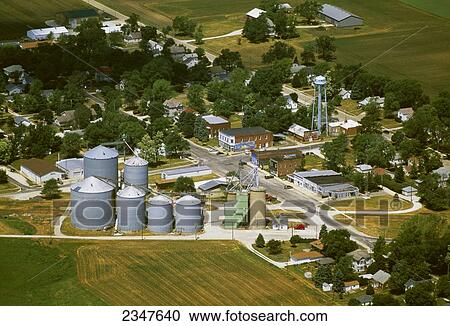 Stock Image - Agriculture - Aerial view of a farm town showing the main street, water tower, grain bins and surrounding fields / Kempton, Illinois, USA.. Fotosearch