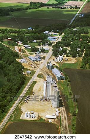 Stock Image - Agriculture - Aerial view of a farm town showing the main street, rail line, grain elevator and surrounding fields / Talmage, Kansas, USA.. Fotosearch