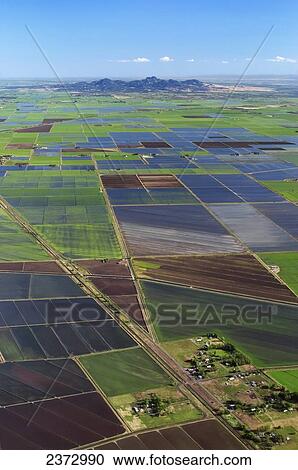 Stock Image - Agriculture - Aerial view of flooded rice fields with the Sutter Buttes in the distance / Sacramento Valley, California, USA.. Fotosearch