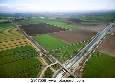 Stock Photo - Agriculture - Aerial view of planted and prepared rectangular and circular center pivot agricultural fields, with an intersecting road and irrigation canal / Florence, Arizona, USA.. Fotosearch