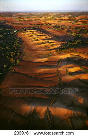 Stock Image - Agriculture - Aerial view of rolling fallow agricultural land in late afternoon light / near Woodbine, Iowa, USA.. Fotosearch
