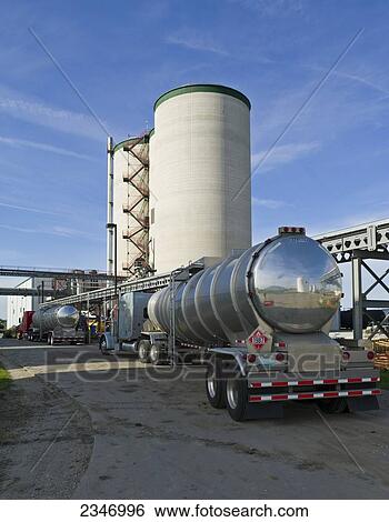 Agriculture - Ethanol production plant. Tank trucks line up to be loaded with ethanol. Grain silos in background / Iowa, USA. View Large Photo Image Stock Photograph - Agriculture - Ethanol production plant. Tank trucks line up to be loaded with ethanol. Grain silos in background / Iowa, USA.. Fotosearch