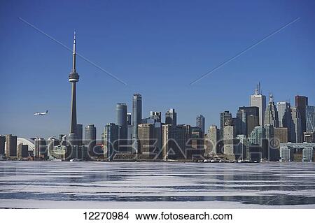 Airplane against city skyline in winter from Ward's Island; Toronto, Ontario, Canada View Large Photo Image Picture - Airplane against city skyline in winter from Ward's Island; Toronto, Ontario, Canada. Fotosearch