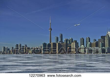 Airplane against city skyline in winter from Ward's Island; Toronto, Ontario, Canada View Large Photo Image Stock Image - Airplane against city skyline in winter from Ward's Island; Toronto, Ontario, Canada. Fotosearch