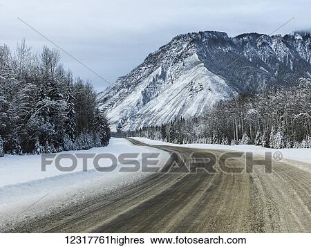Stock Photograph - Alaska highway through the Rocky Mountains in winter; British Columbia, Canada. Fotosearch