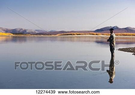Stock Photo - Alaska Native elder fishing in the Noatak River, Noatak, Arctic Alaska, USA, Autumn. Fotosearch