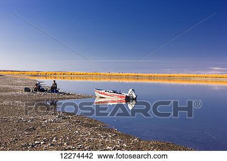 Alaska native elders sit on the bank of the Noatak River with a cooler and stove having a Picnic, Noatak, Arctic Alaska, Autumn View Large Photo Image Stock Image - Alaska native elders sit on the bank of the Noatak River with a cooler and stove having a Picnic, Noatak, Arctic Alaska, Autumn. Fotosearch