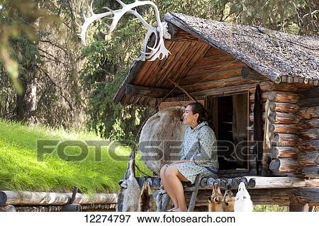 Alaskan Native Indian guide sitting in a Cache speaking about furs at an Athabascan village on the Riverboat Discovery Tour, Fairbanks, Interior Alaska, Summer View Large Photo Image Stock Photo - Alaskan Native Indian guide sitting in a Cache speaking about furs at an Athabascan village on the Riverboat Discovery Tour, Fairbanks, Interior Alaska, Summer. Fotosearch
