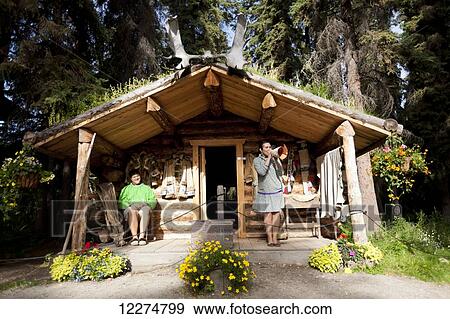 Stock Photo - Alaskan Native Indian guide demonstrating a moose call outside a cabin at an Athabascan village on the Riverboat Discovery Tour, Fairbanks, Interior Alaska, Summer. Fotosearch