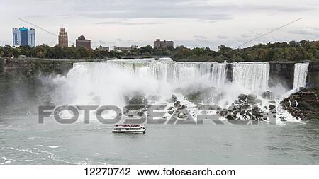Stock Image - American Falls with the Hornblower tour boat on the Canadian side; Niagara Falls, Ontario, Canada. Fotosearch