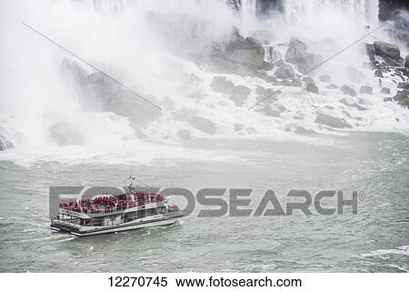 Stock Photography - American Falls with the Hornblower tour boat on the Canadian side; Niagara Falls, Ontario, Canada. Fotosearch