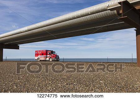 An ambulance driving on the Endicott Island causeway with oil pipelines, Prudhoe Bay Oil field, North Slope, Arctic Alaska, Summer View Large Photo Image Stock Photography - An ambulance driving on the Endicott Island causeway with oil pipelines, Prudhoe Bay Oil field, North Slope, Arctic Alaska, Summer. Fotosearch