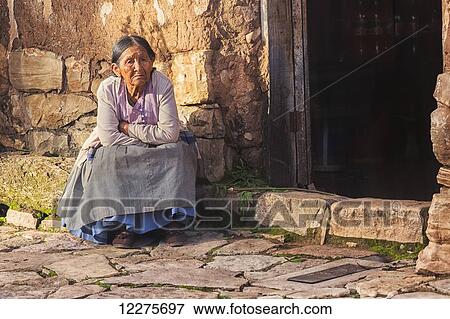 An elderly woman sits at the front of her store; Toro Toro, Bolivia View Large Photo Image Stock Photo - An elderly woman sits at the front of her store; Toro Toro, Bolivia. Fotosearch