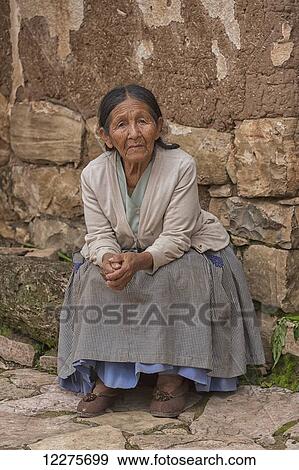 Stock Photo - An elderly woman sits at the front of her store; Toro Toro, Bolivia. Fotosearch