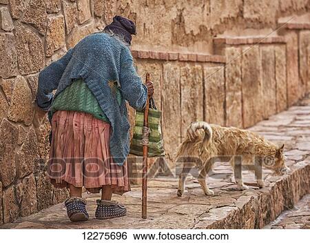 An elderly woman walks down the cobblestone sidewalk; Toro Toro, Bolivia View Large Photo Image Stock Photograph - An elderly woman walks down the cobblestone sidewalk; Toro Toro, Bolivia. Fotosearch