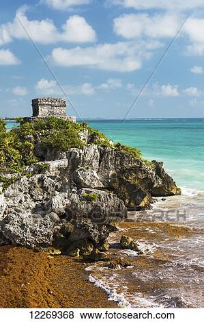 Ancient Mayan Temple on rock cliff overlooking the ocean with blue sky and clouds; Tulum, Quintana Roo, Mexico View Large Photo Image Stock Photo - Ancient Mayan Temple on rock cliff overlooking the ocean with blue sky and clouds; Tulum, Quintana Roo, Mexico. Fotosearch