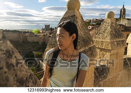 Asian girl sitting on the ancient walls of Segovia; Segovia, Castilla Leon, Spain View Large Photo Image Stock Photograph - Asian girl sitting on the ancient walls of Segovia; Segovia, Castilla Leon, Spain. Fotosearch