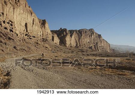 Bamiyan Escarpment With Hundreds Of Caves And The Niche That Contained The Small Buddha Statue Destroyed By The Taliban In 2001, Bamian Province, Afghanistan View Large Photo Image Stock Image - Bamiyan Escarpment With Hundreds Of Caves And The Niche That Contained The Small Buddha Statue Destroyed By The Taliban In 2001, Bamian Province, Afghanistan. Fotosearch