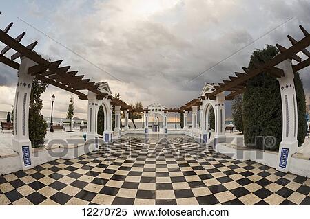 Stock Photography - Black and white checkered tiles on a promenade along the mediterranean; Benidorm, Spain. Fotosearch