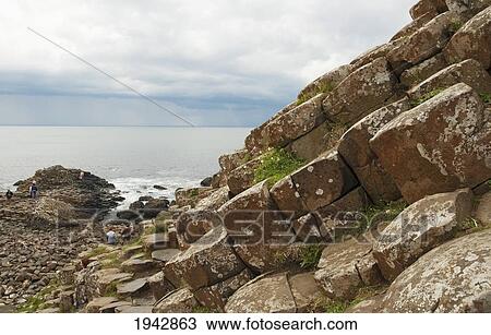 Stock Image - Black Basalt Columns Sticking Out Of The Sea, Giant's Causeway, Northern Ireland, United Kingdom. Fotosearch