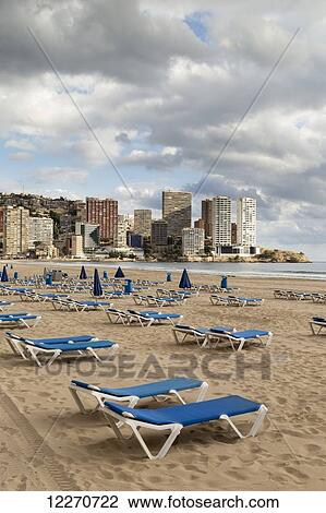 Stock Image - Blue lounge chairs on the beach along the mediterranean; Benidorm, Spain. Fotosearch