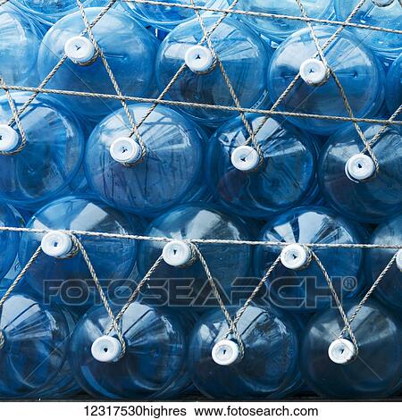 Stock Photograph - Blue plastic water containers with white lids attached by rope; Seoul, South Korea. Fotosearch